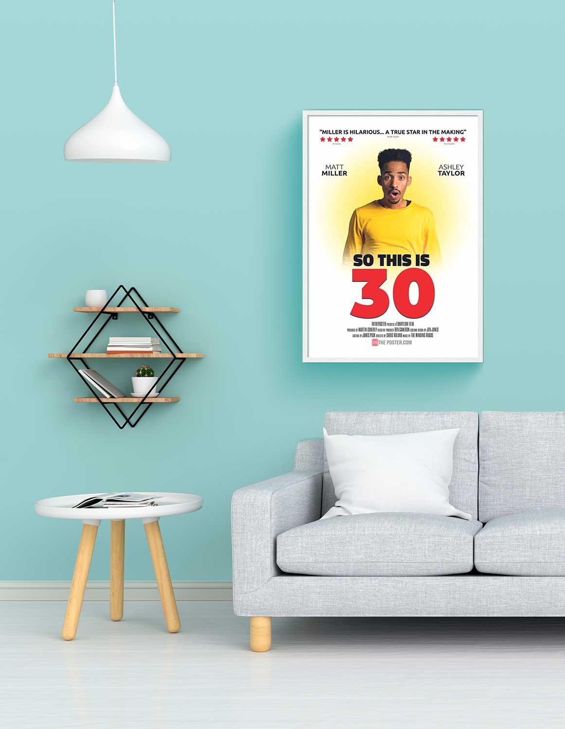 So This is 30 - personalized comedy movie poster, regular size, with a white frame on a wall above a sofa