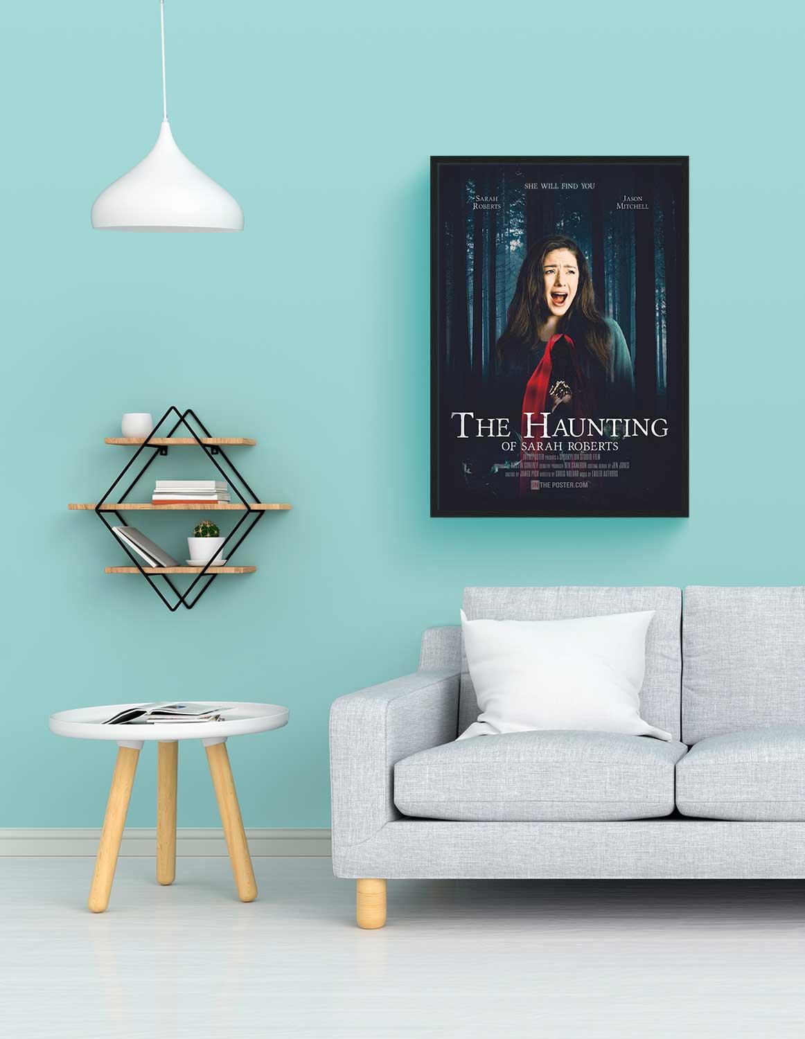The Haunting Personalised film poster, regular size in a black frame, above a sofa with a blue wall.