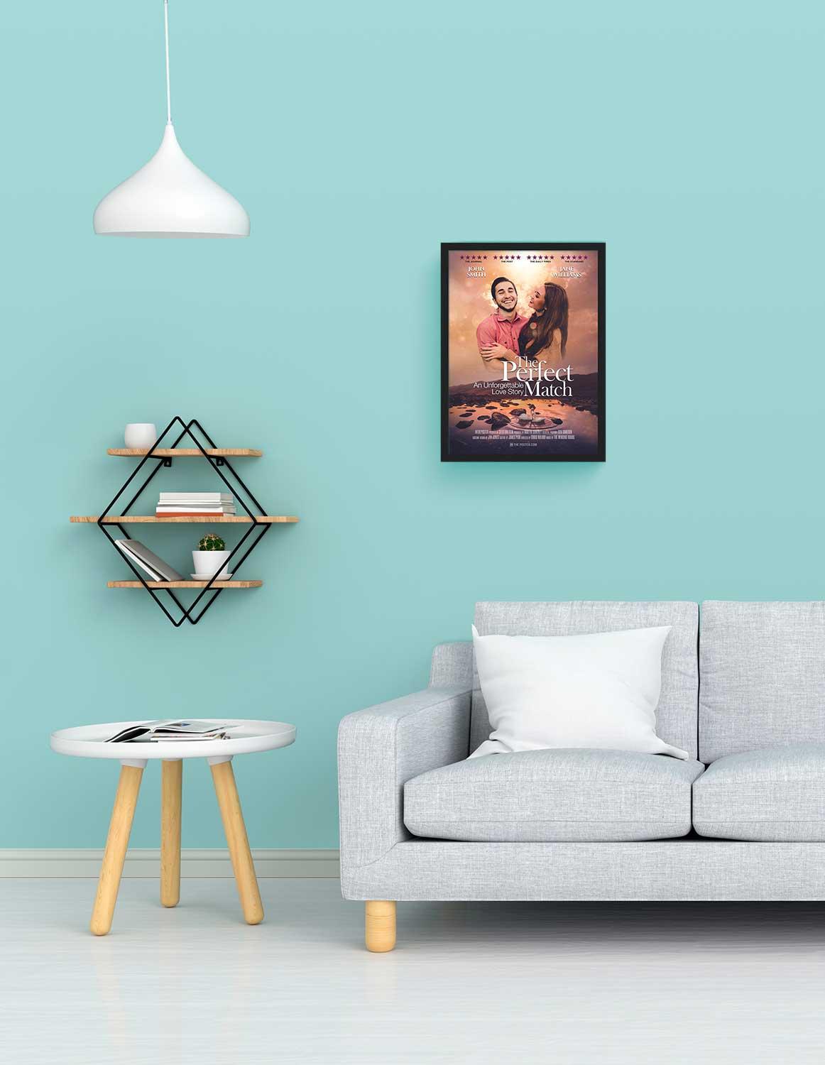 The perfect match romantic movie poster in a small black frame on a blue wall above a grey modern sofa