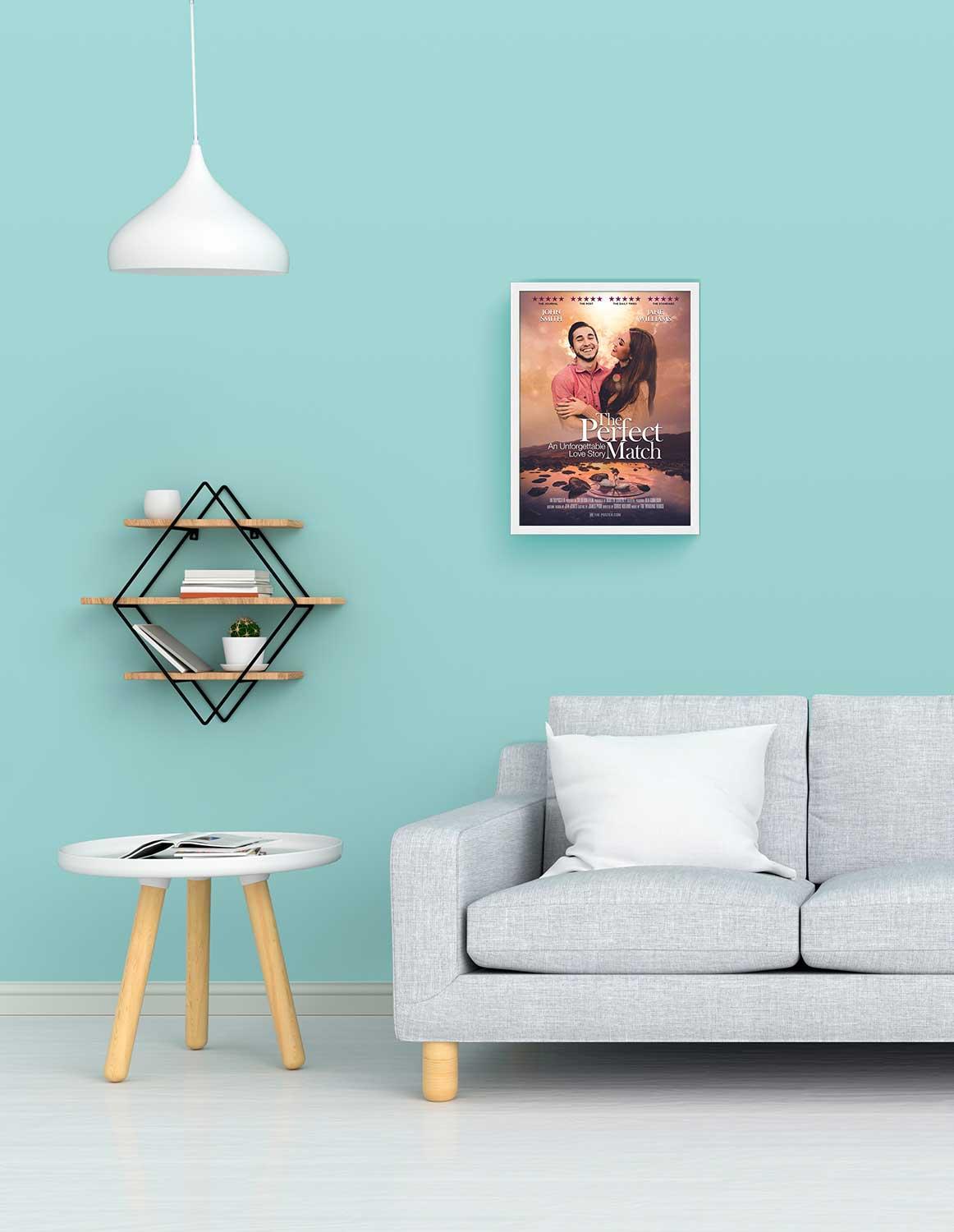 The perfect match romantic movie poster in a small white frame on a blue wall above a grey modern sofa